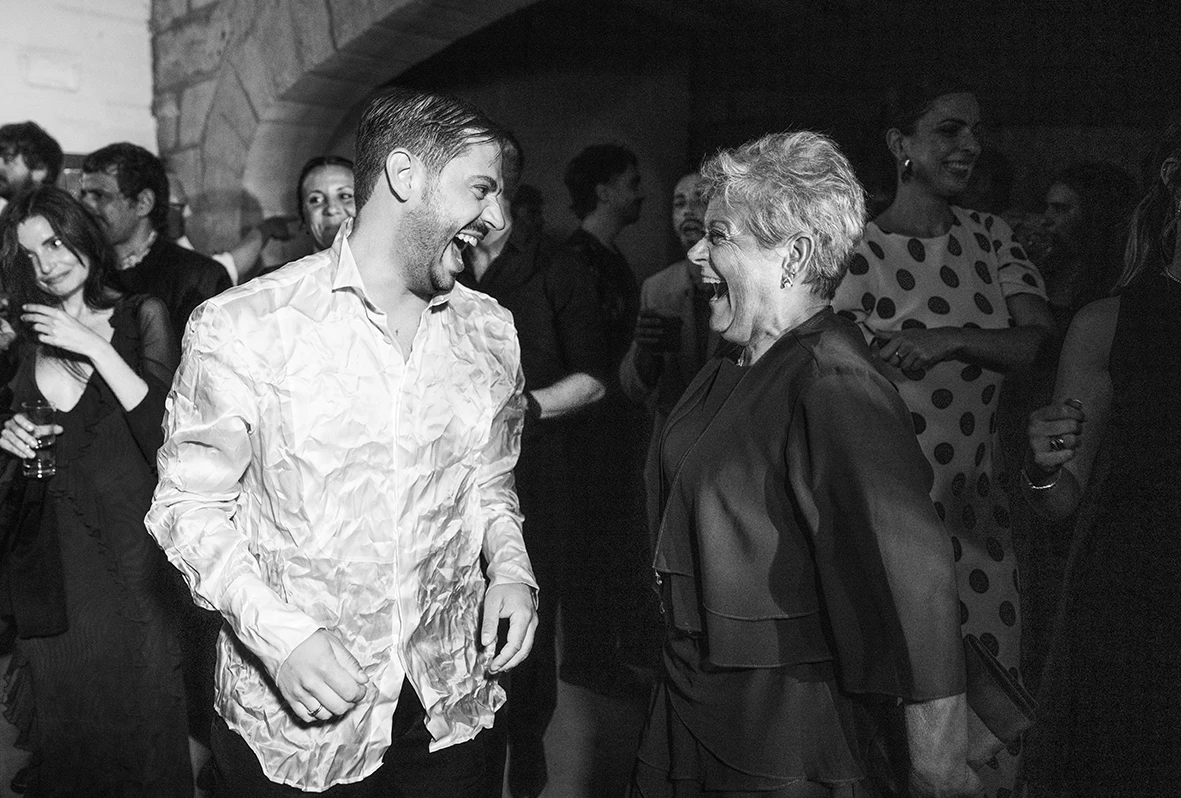 Santi sharing a joyful moment with an older guest at his wedding at Finca Gordiola.