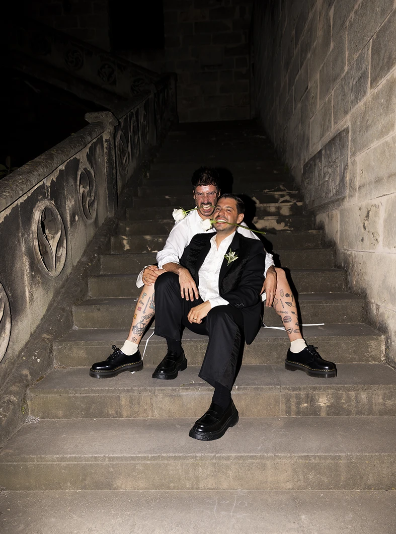 Jon and Santi sitting on the stone staircase at night during their wedding at Finca Gordiola.