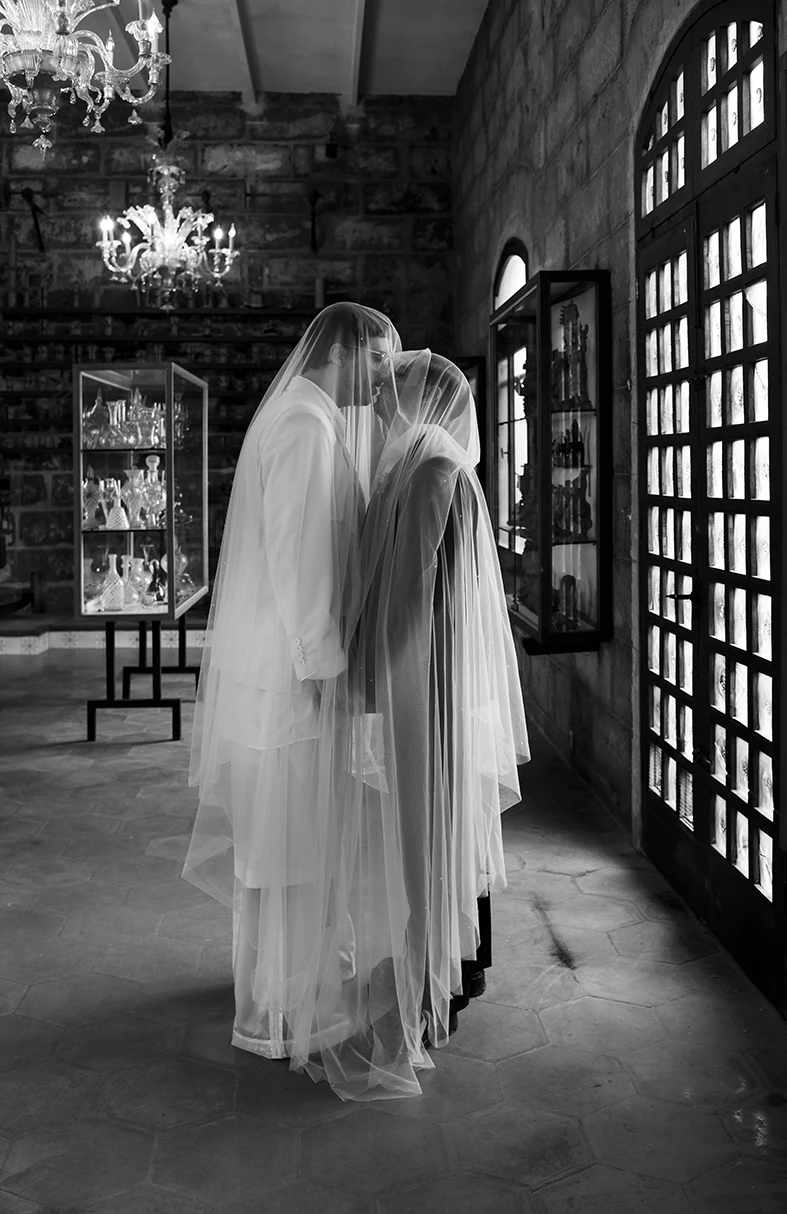 Jon and Santi sharing a tender kiss while wearing veils at their wedding at Finca Gordiola.