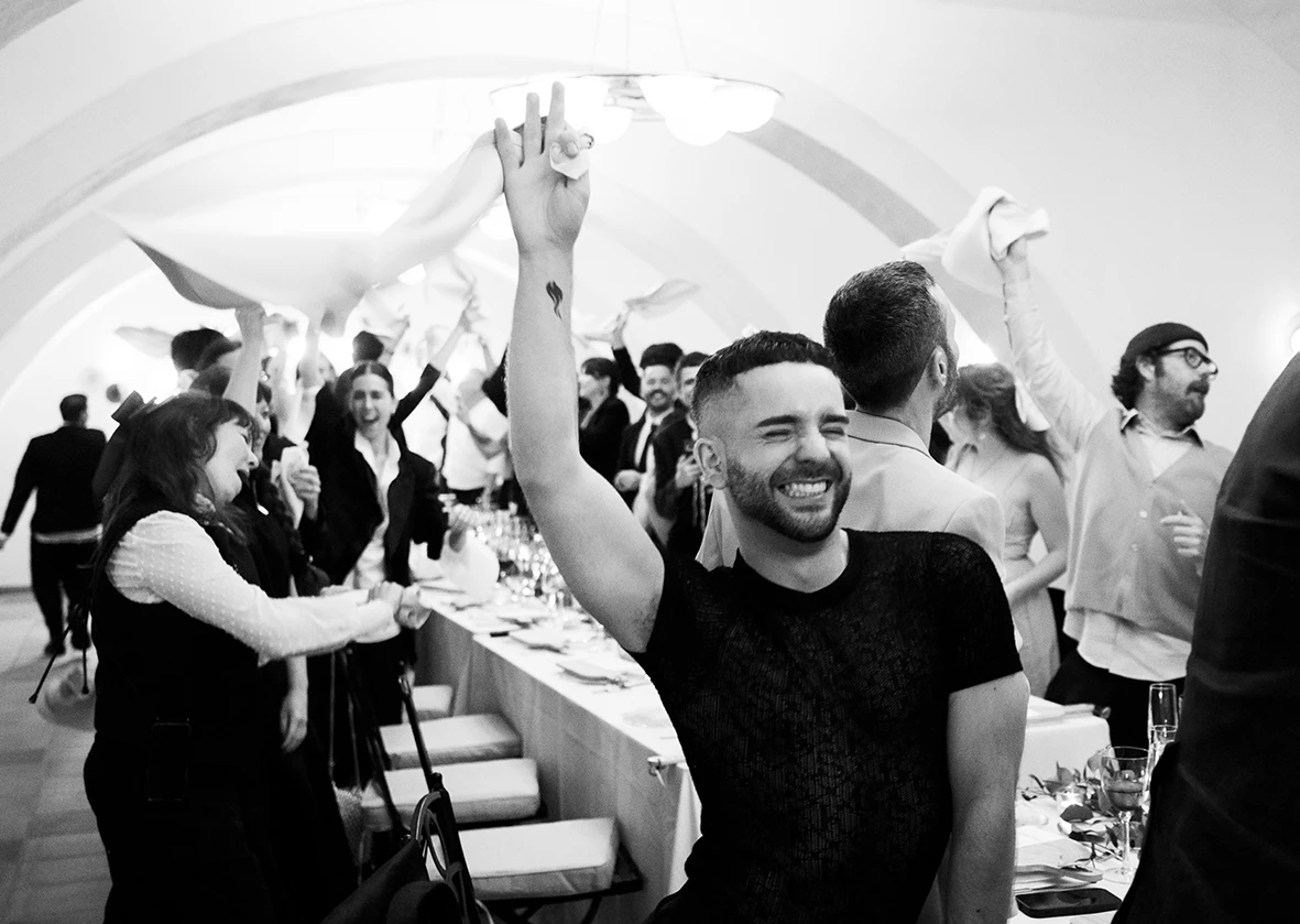 Wedding guests waving napkins in celebration during Jon and Santi’s wedding at Finca Gordiola.