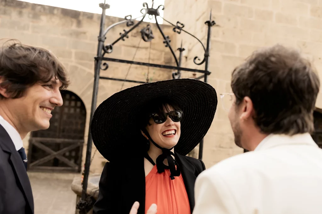 Stylish wedding guest in black hat at Finca Gordiola Mallorca wedding.