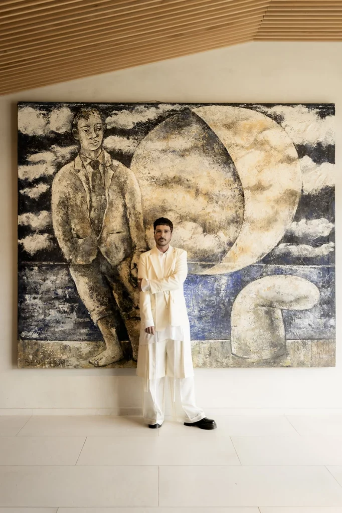 Jon posing before his wedding at Finca Gordiola Mallorca, in front of a modern art mural.