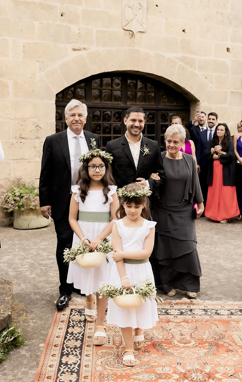 Family and flower girls posing at the entrance of Finca Gordiola Mallorca.