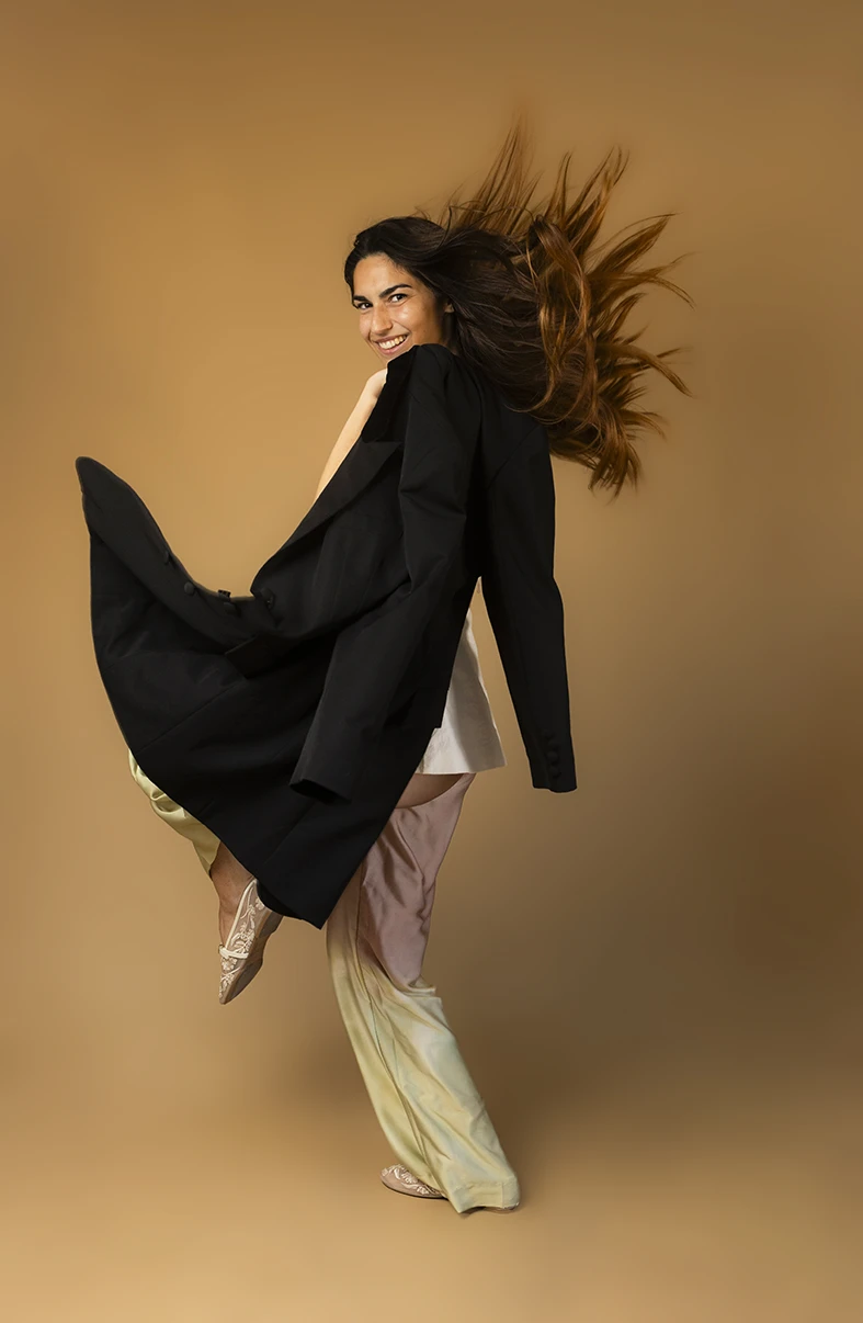 Modelo en movimiento, con abrigo al viento y mirada segura, durante una sesión en estudio. Cómo puedes ser modelo en Mallorca. Foto de Inma del Valle.