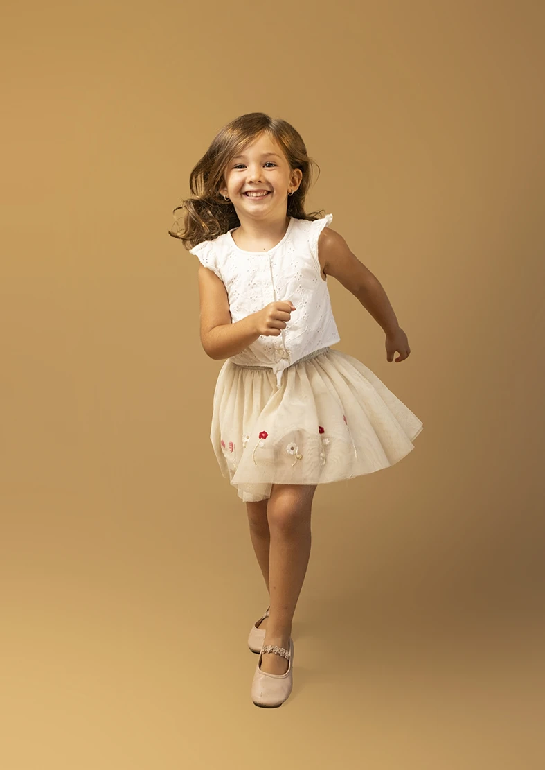 Niña corriendo con vestido blanco. Fotógrafo de niños para agencia en Mallorca