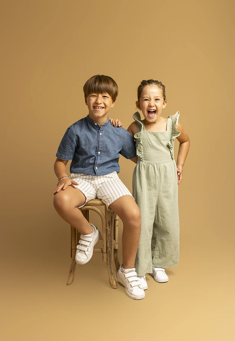 Niño y niña posando con actitud alegre. Fotógrafo de niños para agencia en Mallorca.