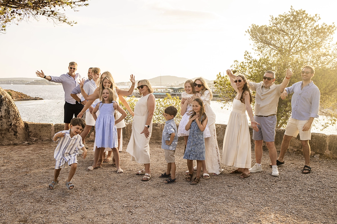 Fotógrafo familiar en Mallorca, familia de varias generaciones posando de forma divertida frente al mar. Fotografía de Inma del Valle.