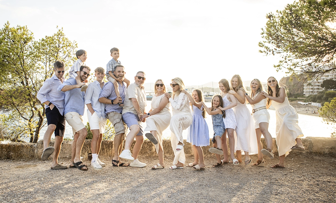 Fotógrafo familiar en Mallorca, retrato grupal de una gran familia celebrando juntos al aire libre. Imagen capturada por Inma del Valle.