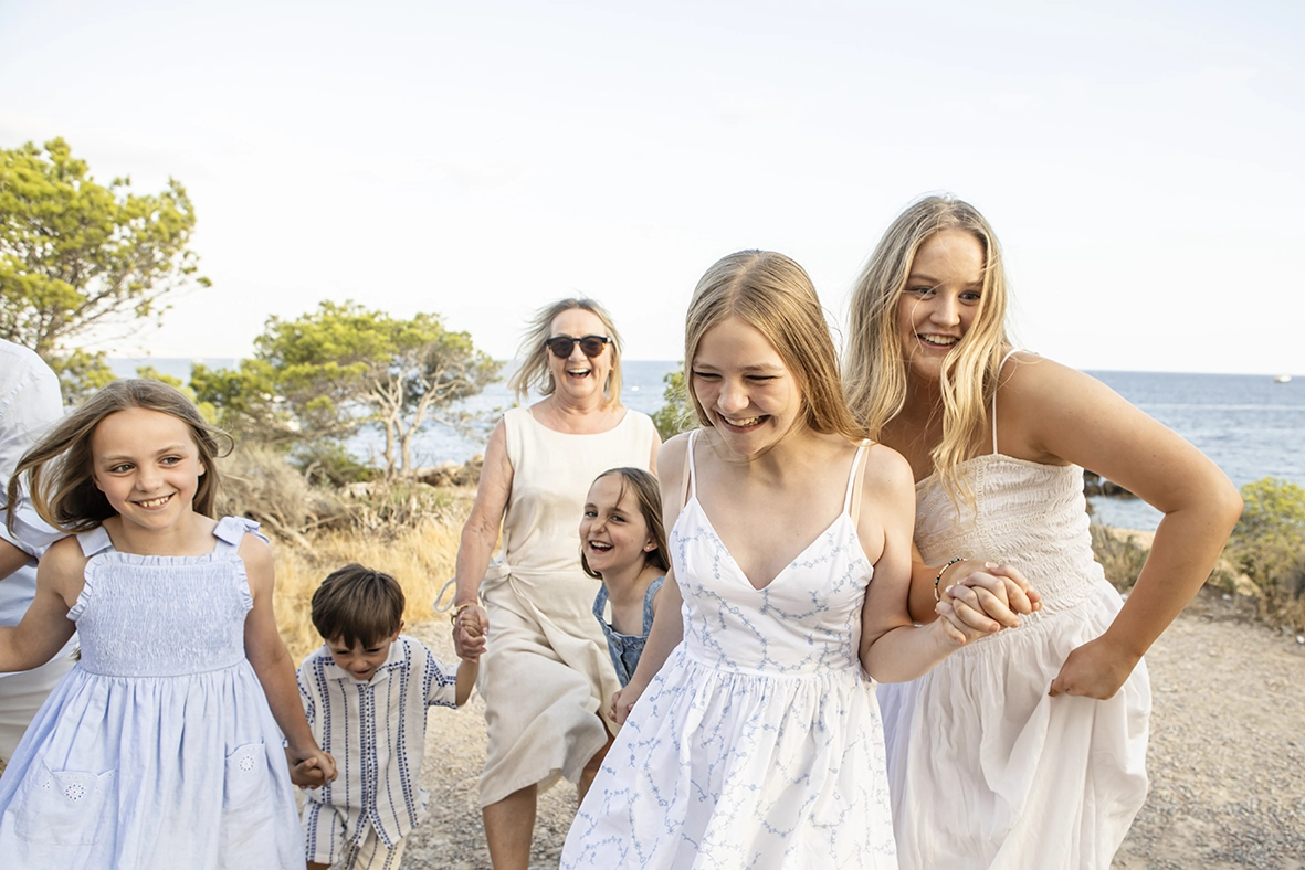 Fotógrafo familiar en Mallorca, grupo de niños y mujeres caminando y riendo en la naturaleza. Foto de Inma del Valle.