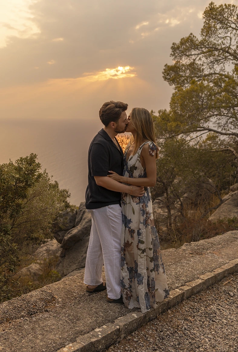 Couple kissing at sunset by the sea in Mallorca. Photo by Inma del Valle, photographer of marriage proposals in Mallorca.