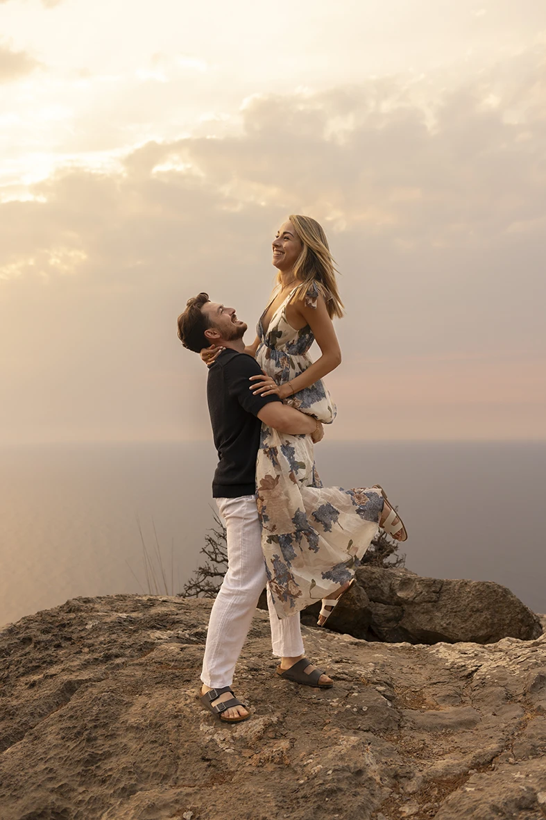 Groom lifting his fiancée after the sunset proposal. Photo by Inma del Valle, photographer of marriage proposals in Mallorca.