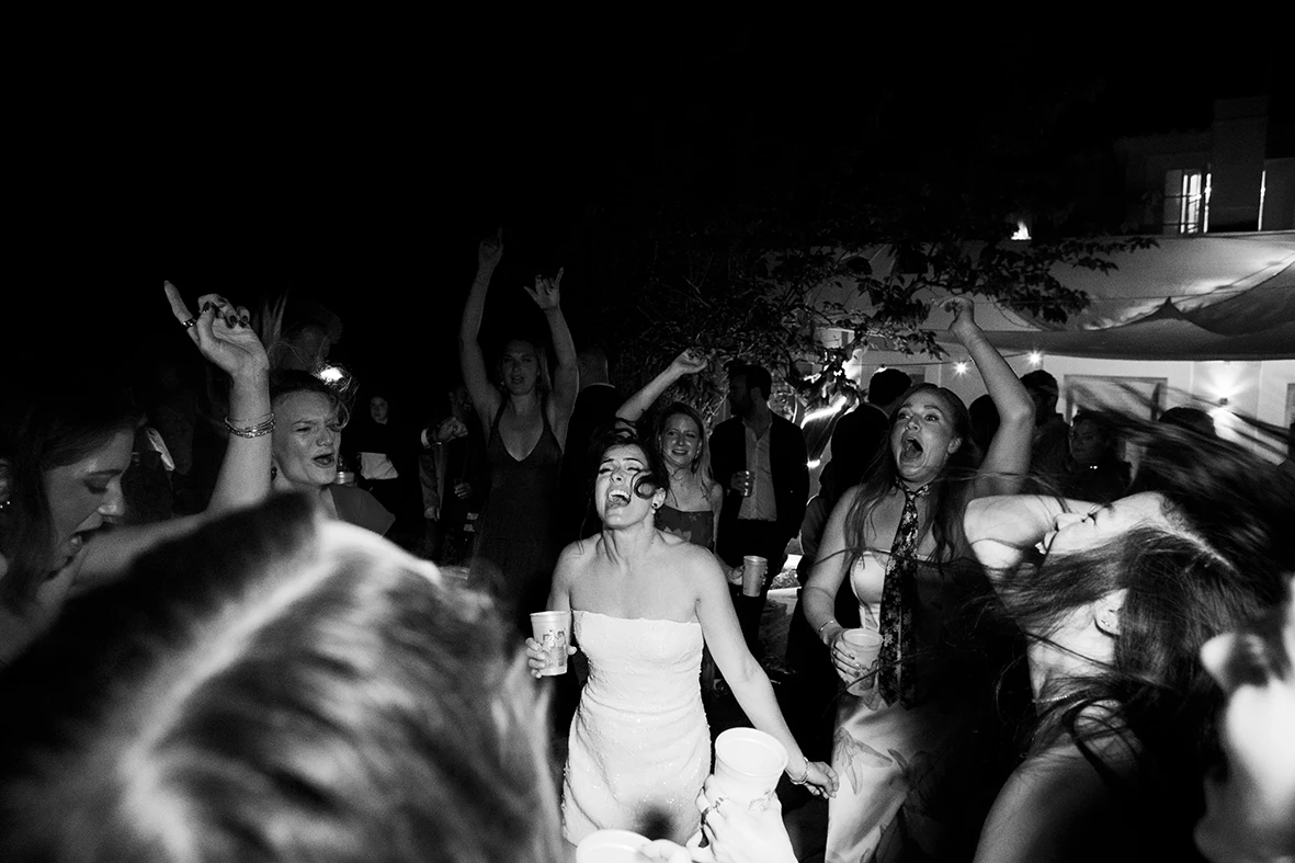 Novia bailando entre la multitud con su vestido de novia para la fiesta. Fotografía de Inma del Valle.