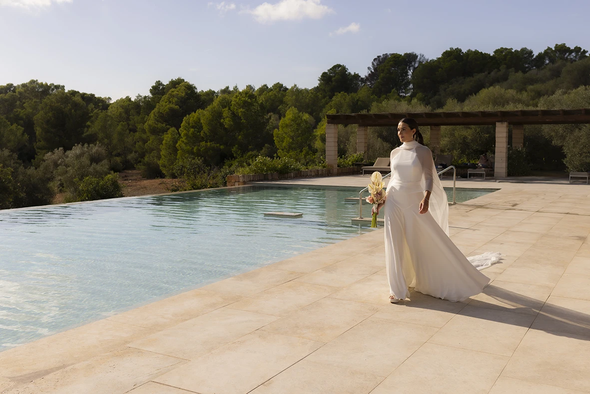 La novia camina junto a la piscina en un entorno natural – Wedding photographer in Mallorca – Inma del Valle -.