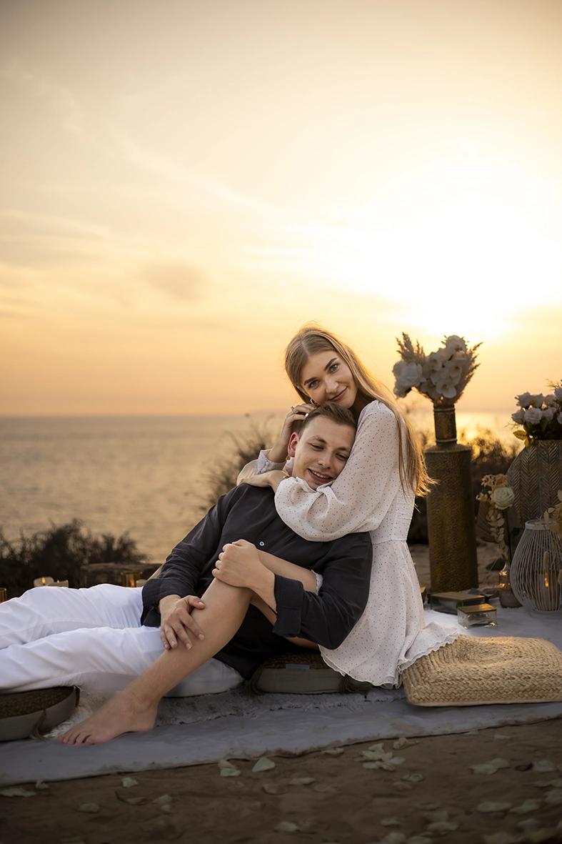 Pareja abrazada al atardecer con el mar de fondo, fotografía realizada por un fotógrafo para pedida de mano en Mallorca.