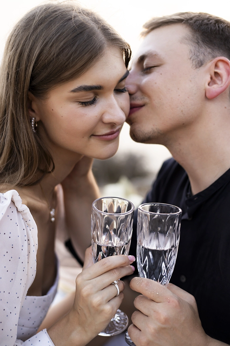 Couple toasting with crystal glasses and sharing a romantic moment during their proposal in Mallorca. Captured by a photographer for proposals in Mallorca.