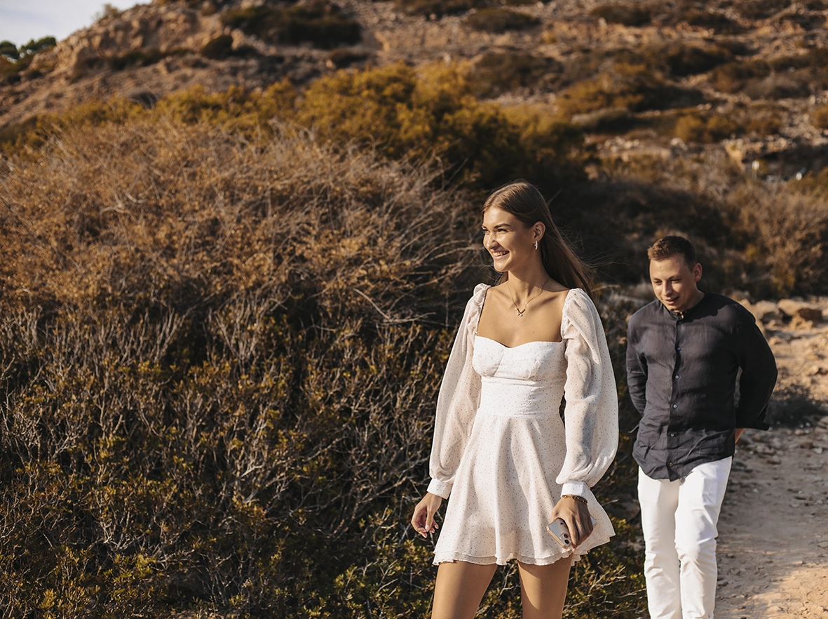 Couple happily walking through nature during their proposal in Mallorca. Captured by a photographer for proposals in Mallorca.