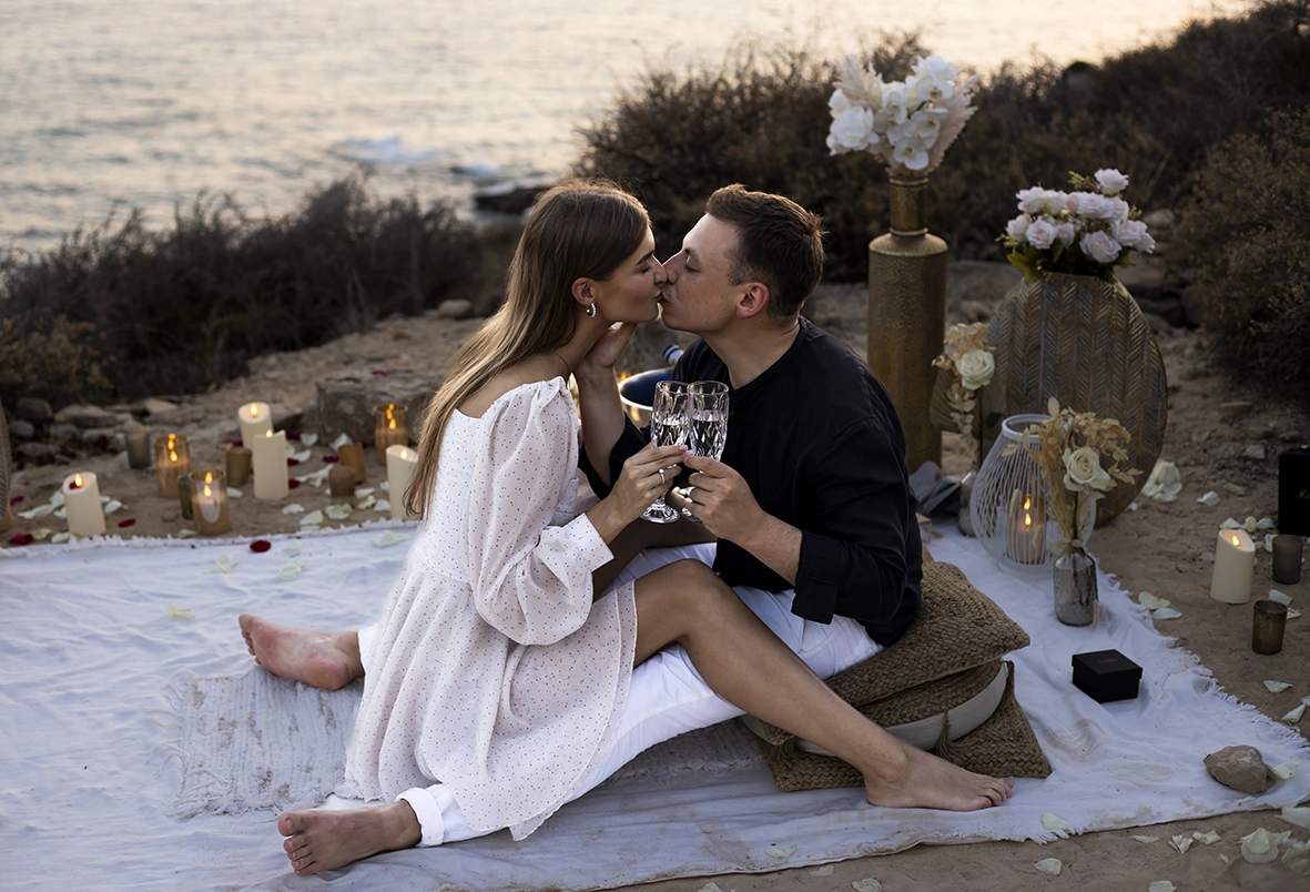 Pareja brindando y besándose en una pedida de mano en Mallorca, captada por un fotógrafo para pedida de mano en Mallorca.