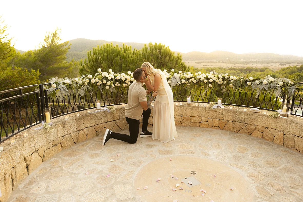 Emotional marriage proposal in Mallorca surrounded by flowers at sunset.