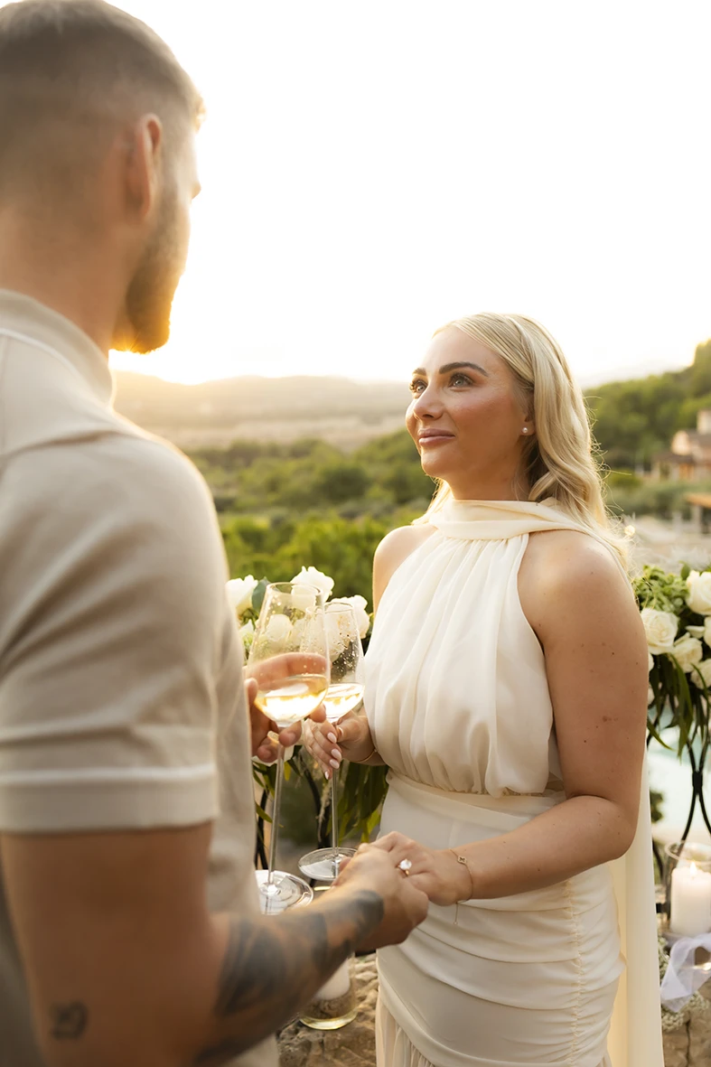 Bride-to-be smiling with a glass of champagne after a proposal in Mallorca.