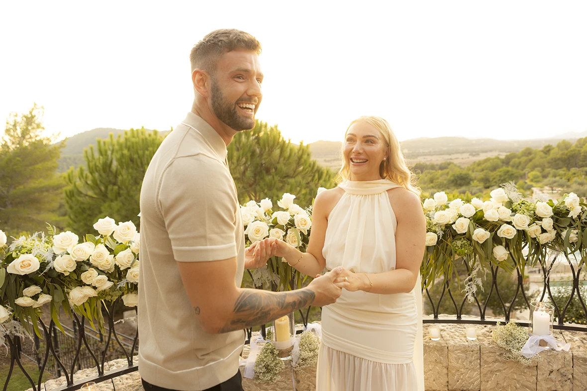 Couple smiling and holding hands during their proposal in Mallorca.