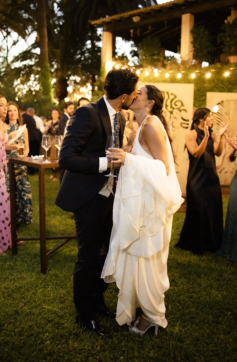 Bride and groom sharing a romantic kiss during their wedding party in Mallorca.