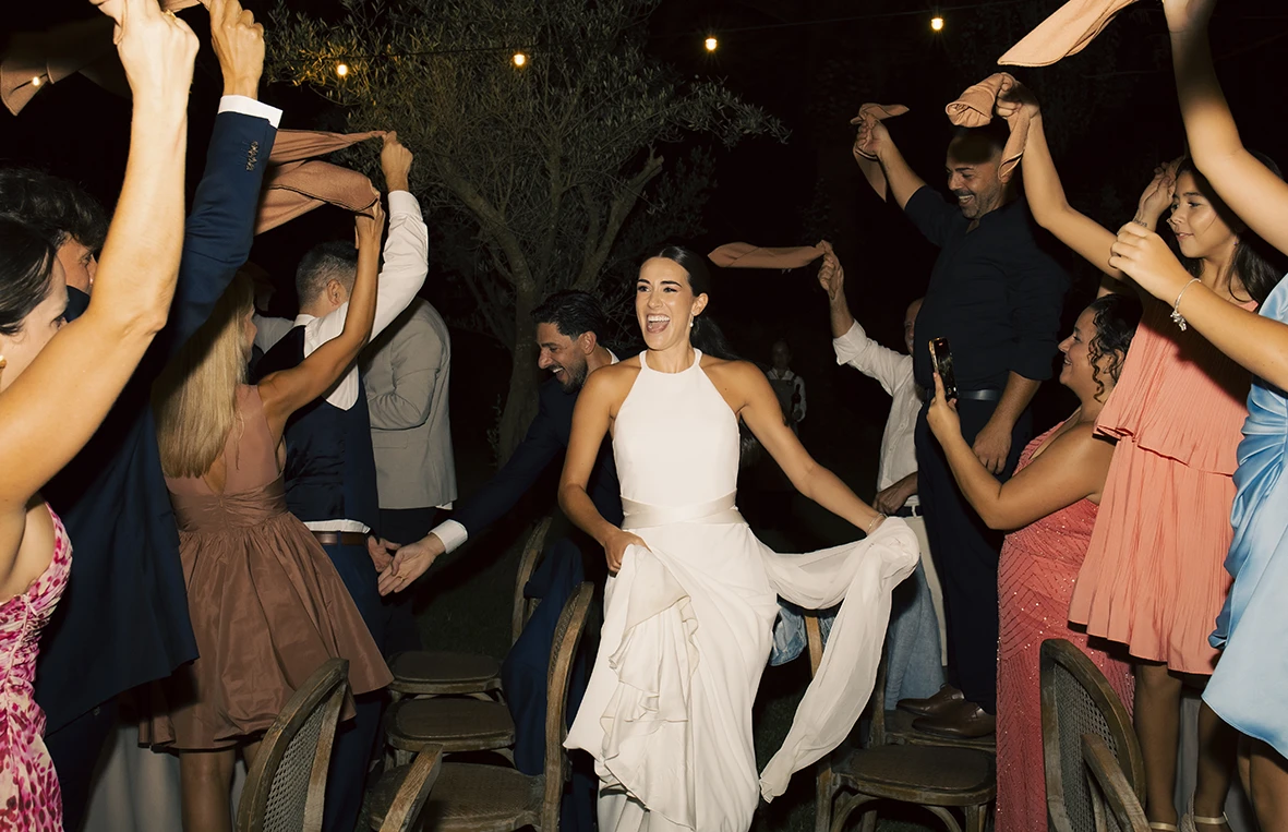 Bride dancing surrounded by guests during a lively wedding celebration in Mallorca.