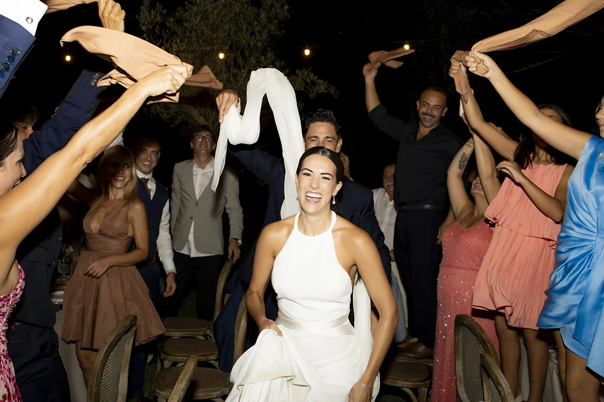 Bride lifted on a chair while guests celebrate during a lively wedding party in Mallorca.