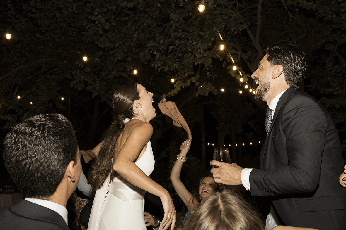 Bride and groom laughing and dancing together during their wedding party in Mallorca.