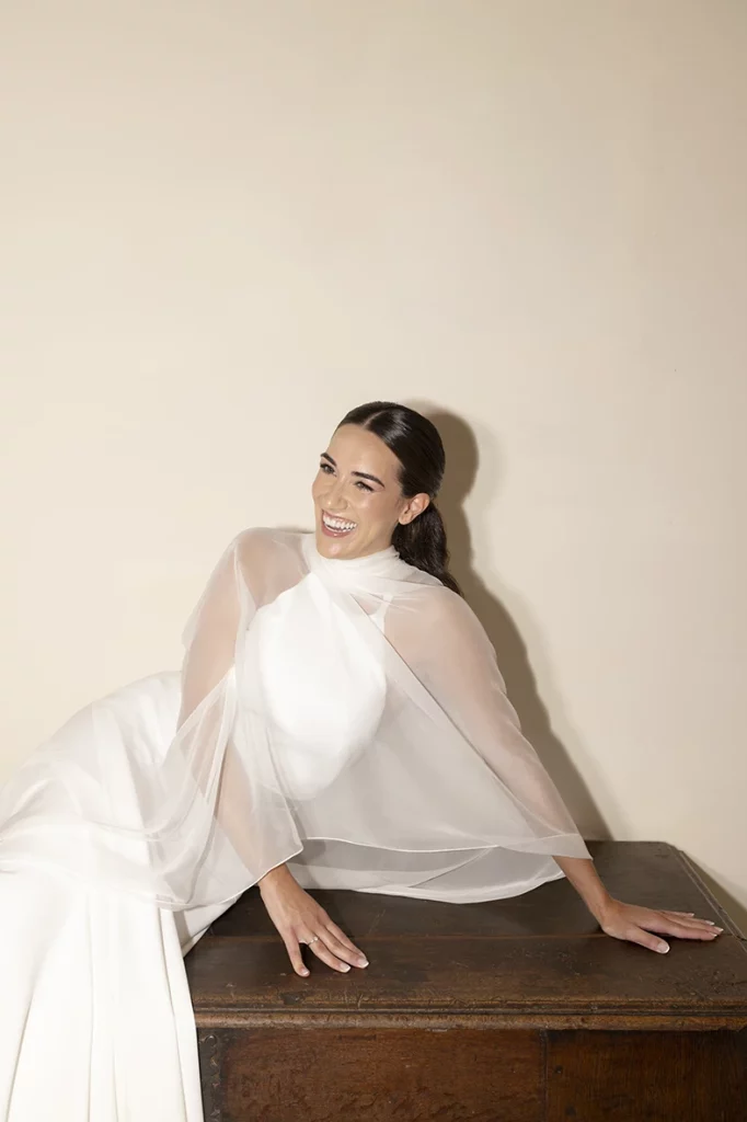 Bride reclining gracefully on a cabinet, smiling softly – Wedding photographer in Mallorca – Inma del Valle –