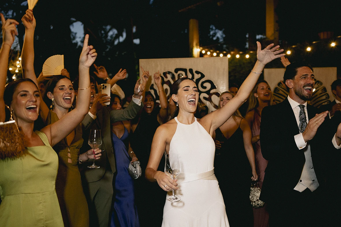 Bride dancing joyfully with friends during the wedding celebration in Mallorca.