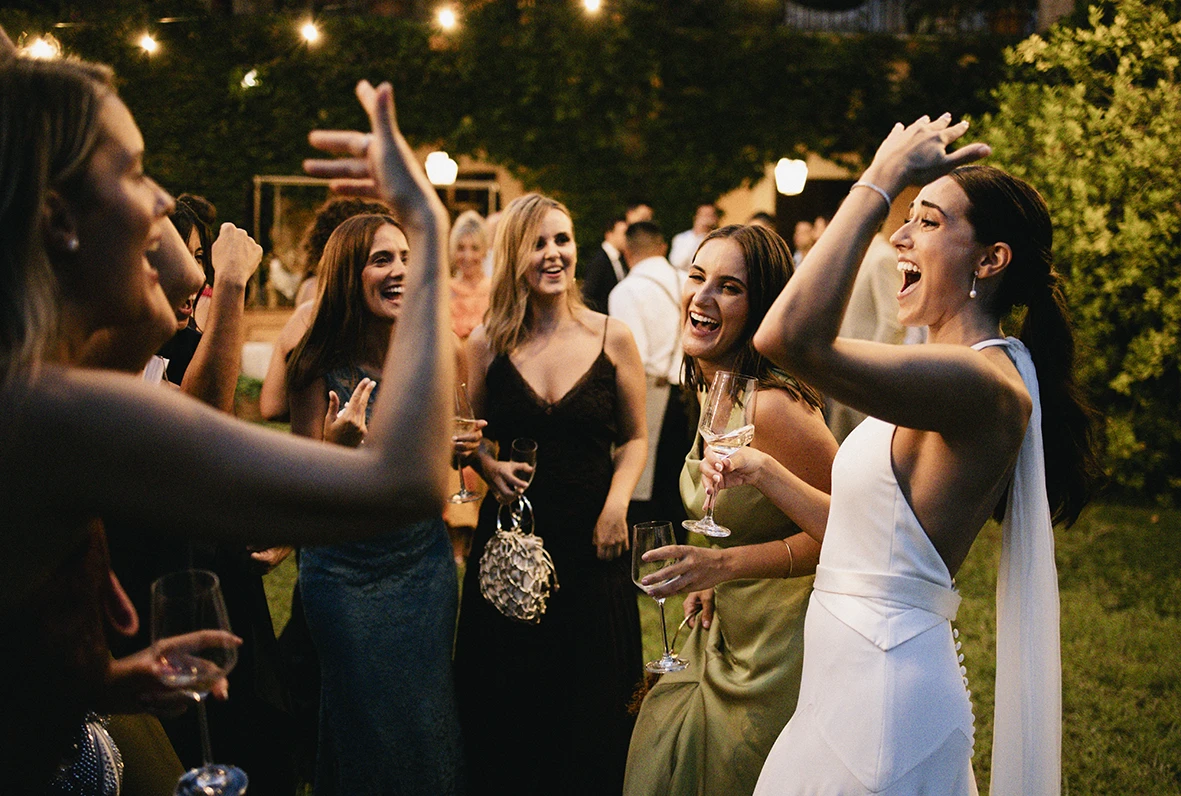 Guests and bride dancing and celebrating at an outdoor wedding party in Mallorca.