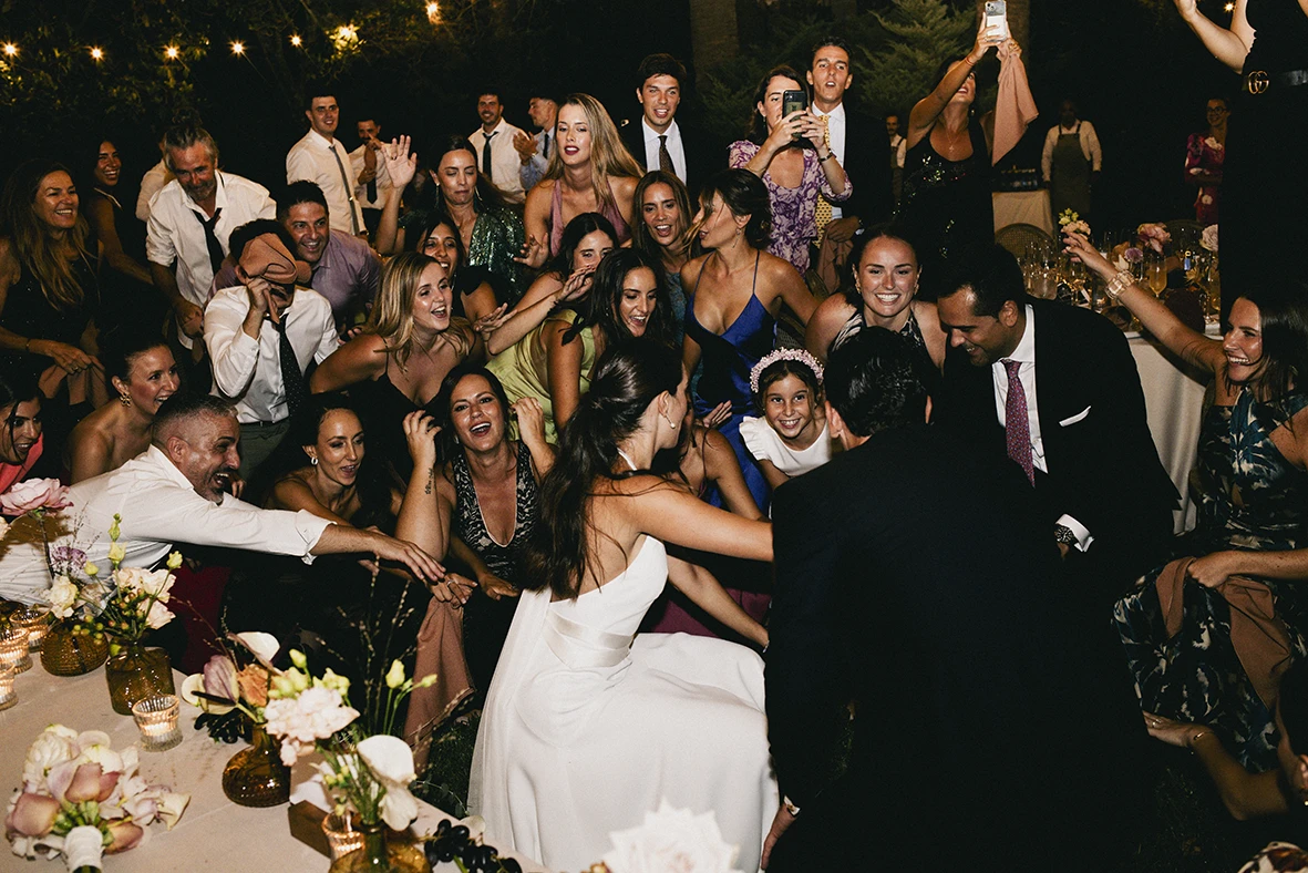 Bride and groom celebrating on the dance floor surrounded by cheering guests at their Mallorca wedding.