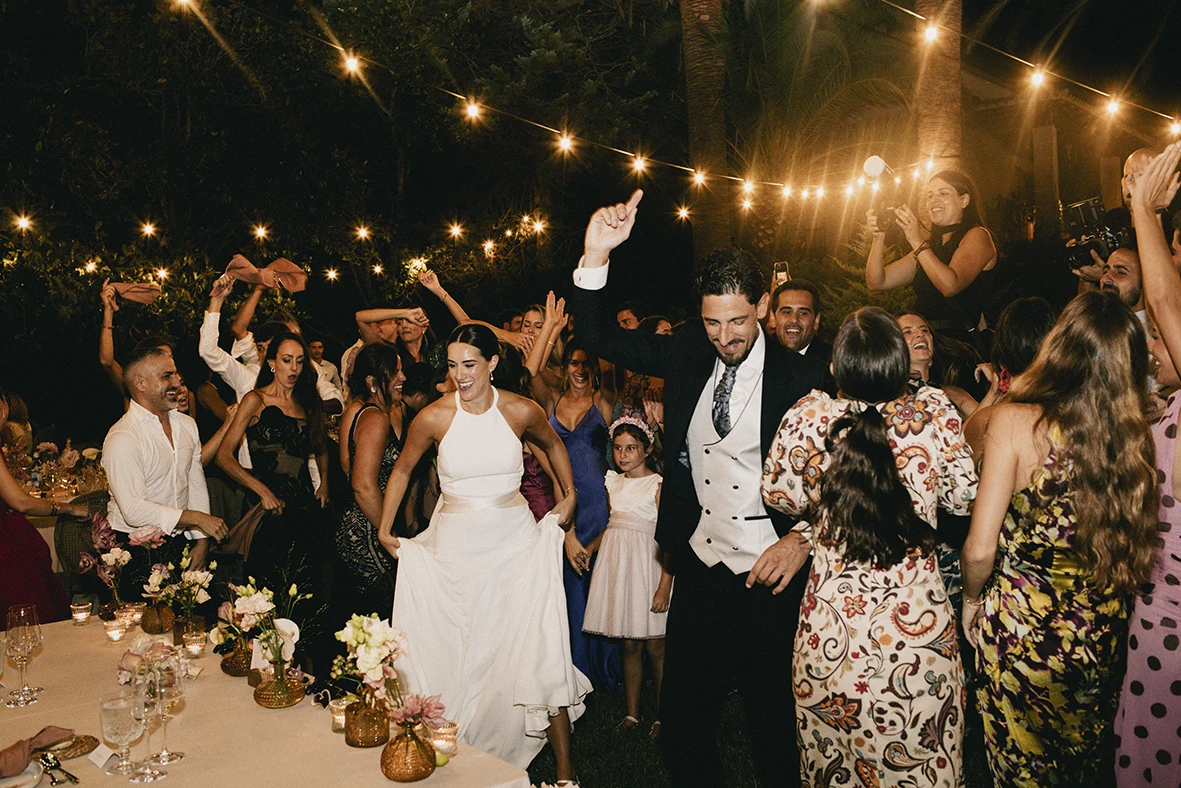 Bride and groom dancing with guests during a joyful wedding celebration in Mallorca.