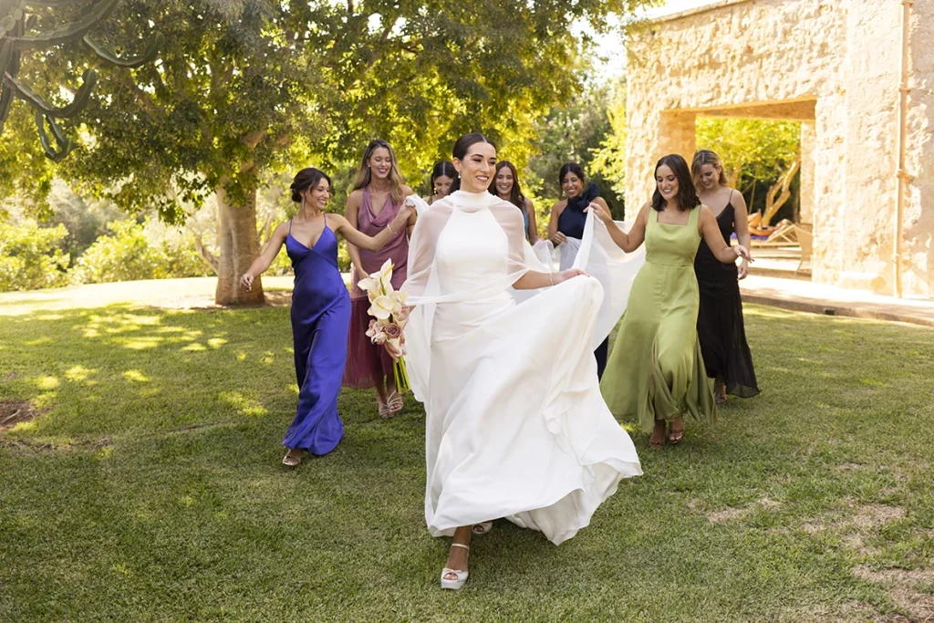 The bride joyfully runs with her bridesmaids – Wedding photographer in Mallorca – Inma del Valle -