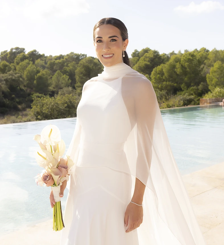 Portrait of the bride standing by the pool holding her bouquet – Wedding photographer in Mallorca – Inma del Valle -