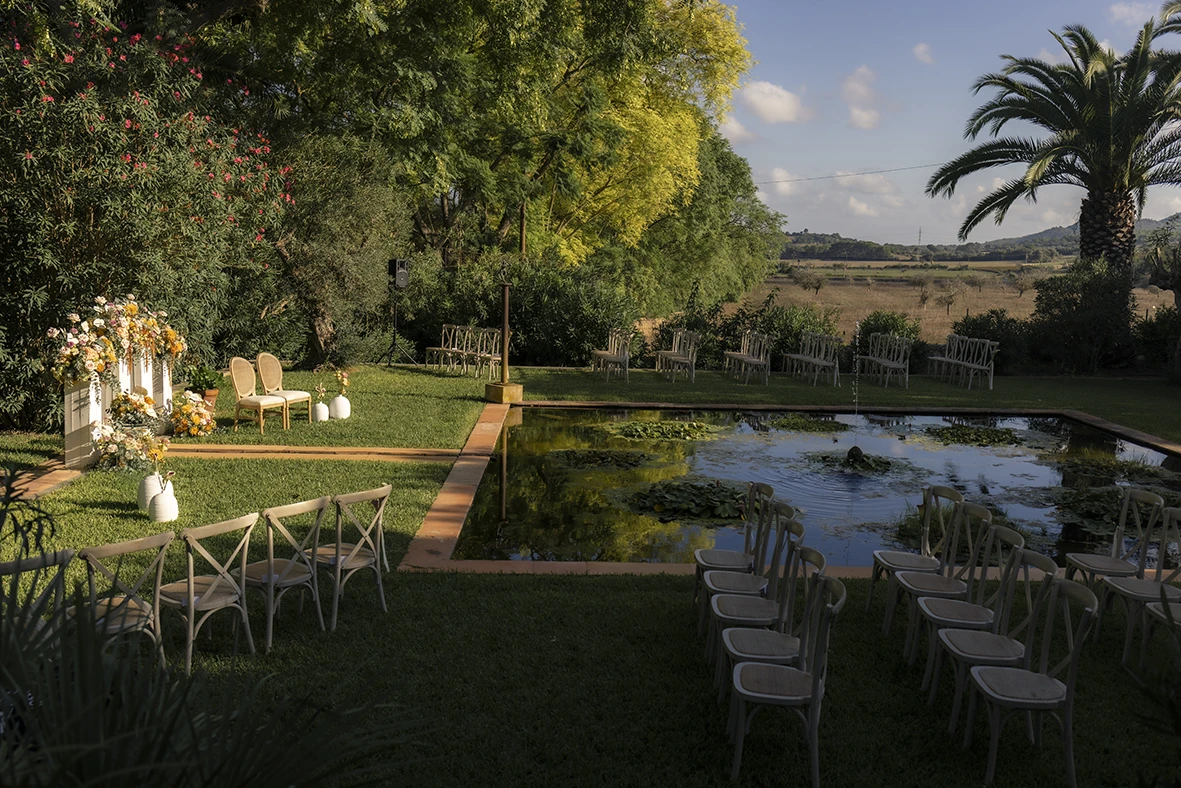 Outdoor wedding ceremony setup beside a pond – Wedding photographer in Mallorca – Inma del Valle -