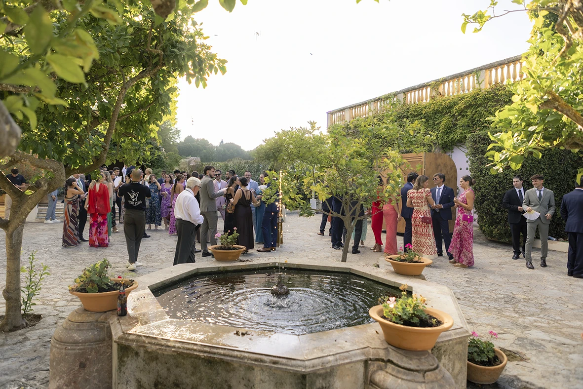 Stone fountain and guests arriving at Finca Santa Cirga – Wedding photographer in Mallorca – Inma del Valle -