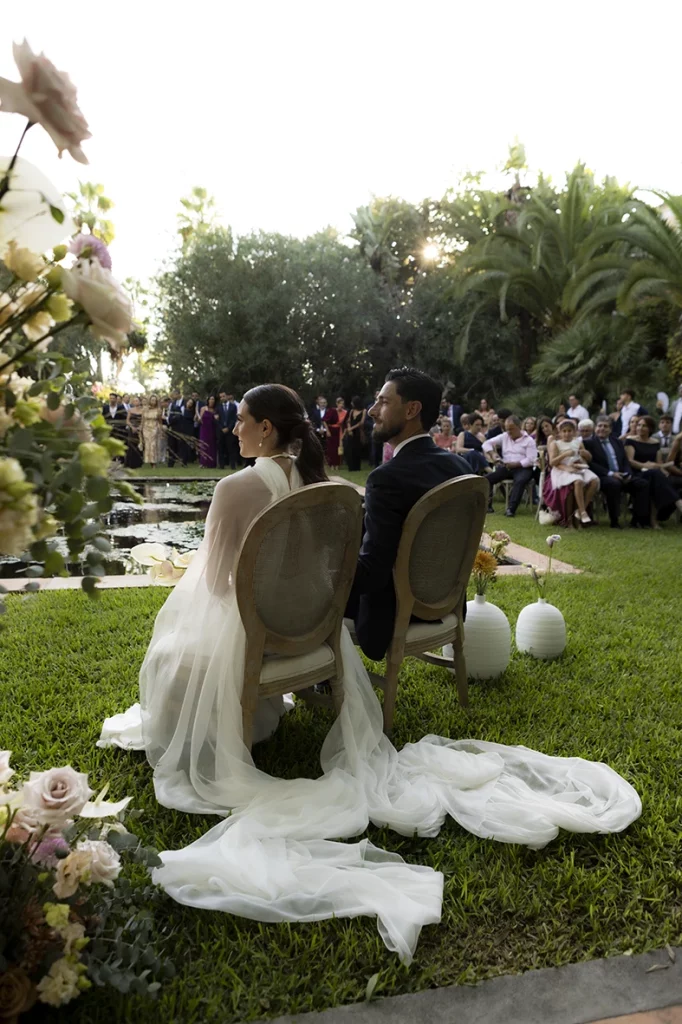 Bride and groom seated from behind during the ceremony at Finca Santa Cirga – Wedding photographer in Mallorca – Inma del Valle -