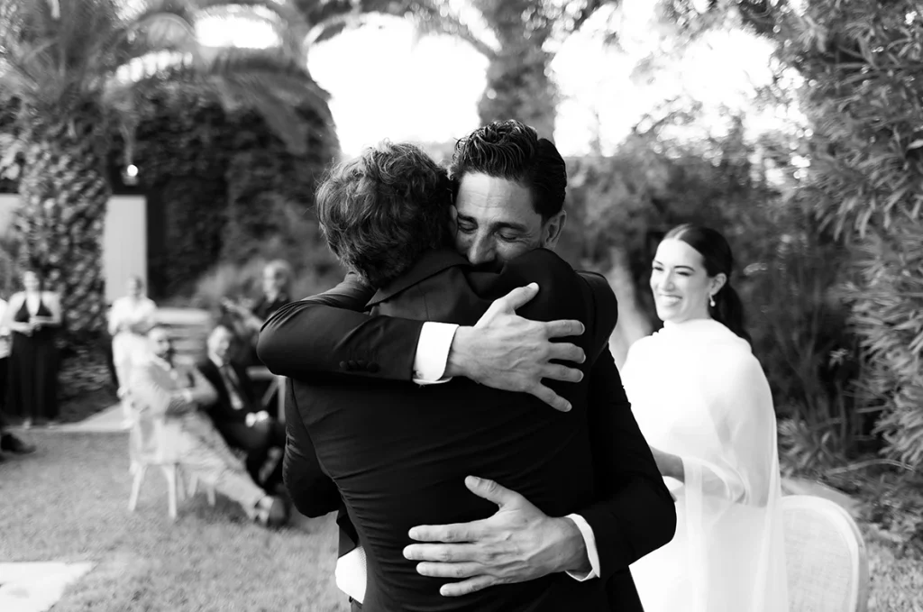 Groom hugging a guest after the ceremony at Finca Santa Cirga – Wedding photographer in Mallorca – Inma del Valle -
