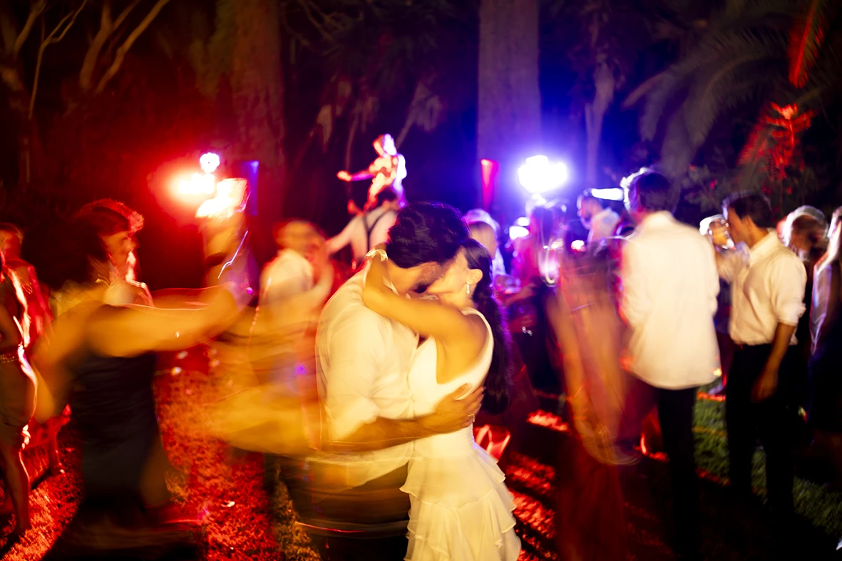 Bride and groom hugging on the dance floor with colorful lights – Wedding photographer in Mallorca – Inma del Valle