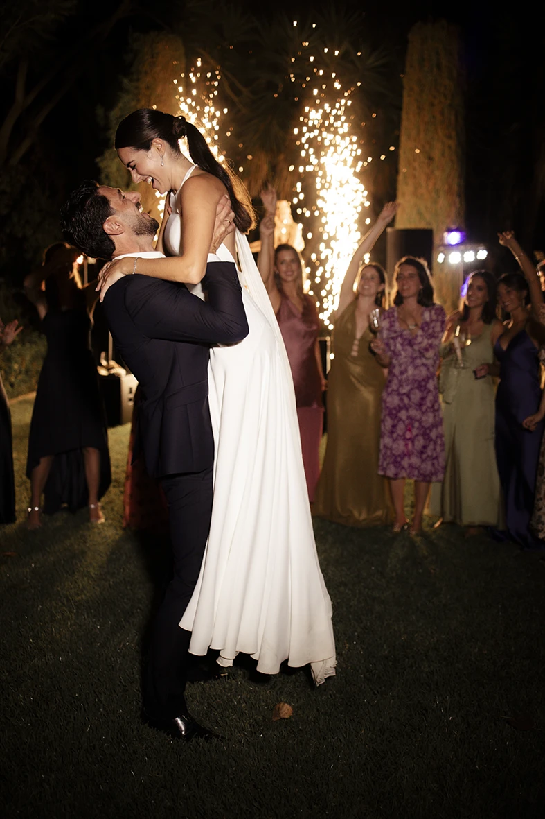 Groom lifting the bride among cold fireworks at Finca Santa Cirga – Wedding photographer in Mallorca – Inma del Valle