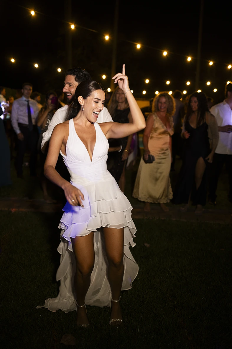 The bride dancing with joy under string lights at Finca Santa Cirga – Wedding photographer in Mallorca – Inma del Valle