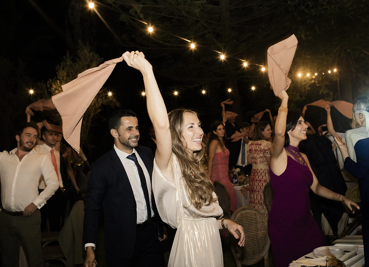 Wedding guests waving napkins and celebrating in Mallorca – Wedding photographer in Mallorca – Inma del Valle –