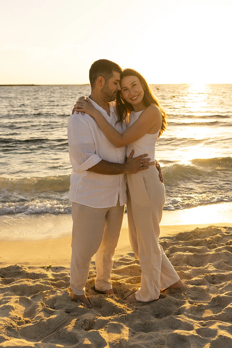 Pareja abrazada frente al mar al atardecer durante una sesión con fotógrafo en Mallorca