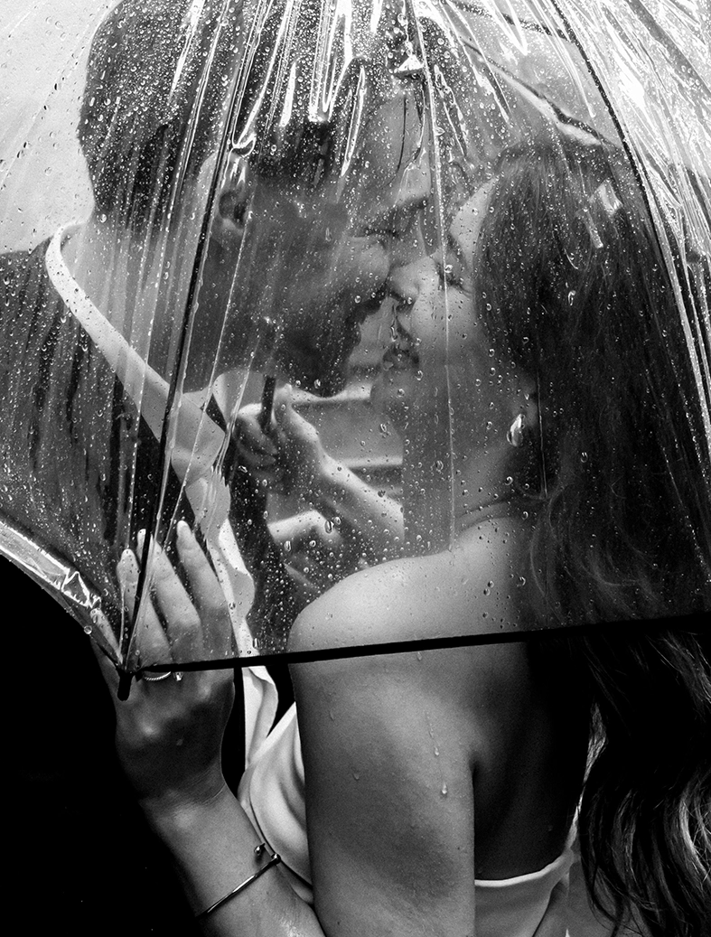 Daiana y Noah se miran bajo la lluvia cubiertos por un paraguas transparente