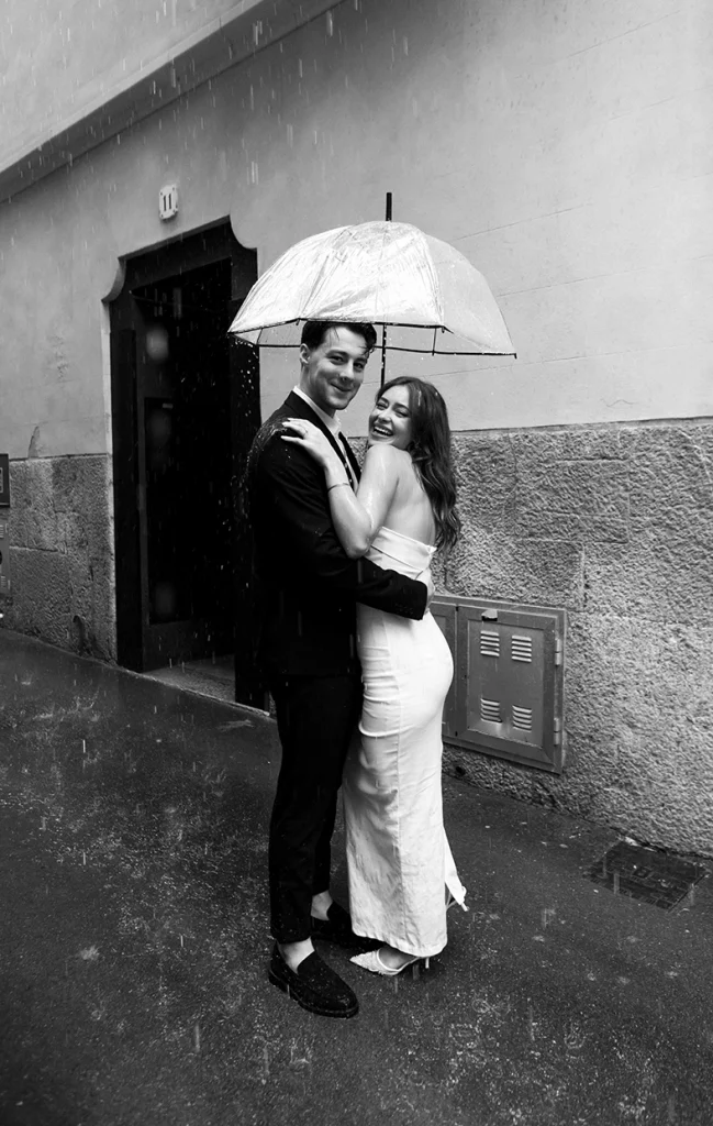 Daiana y Noah sonríen bajo un paraguas en un día lluvioso en Palma
