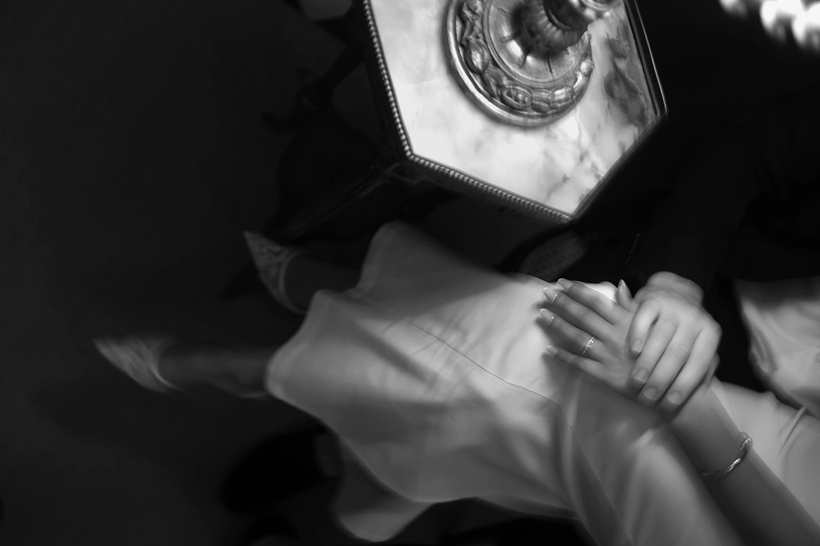 detalle en blanco y negro de la mano de Daiana junto a una mesa de mármol
