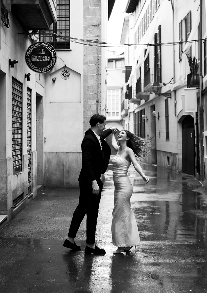 Daiana y Noah bailan bajo la lluvia durante su fotografía de pareja en Mallorca