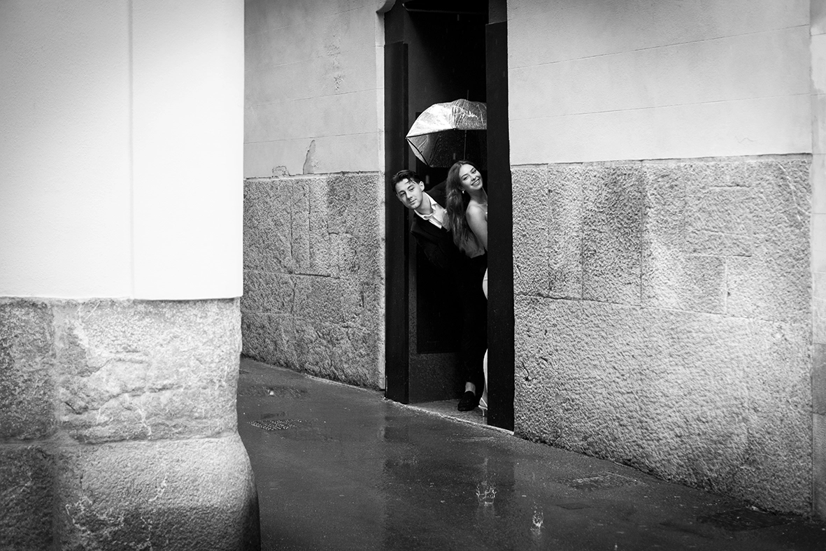 Daiana y Noah asomándose desde una puerta mientras llueve en Palma