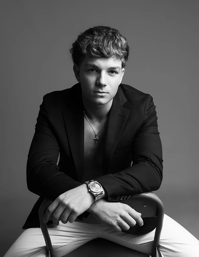 Retrato en blanco y negro de modelo masculino con americana, mirando a cámara con expresión seria
